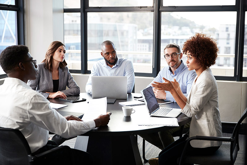 managers having a meeting at a table with computers