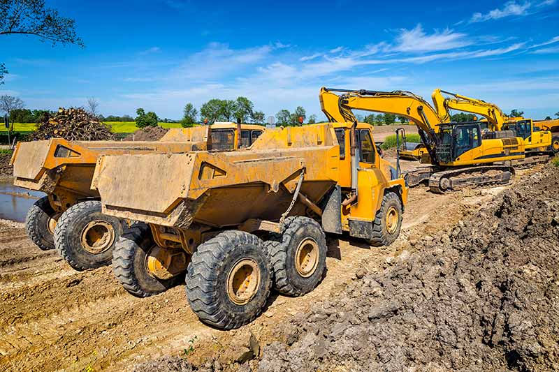row of heavy equipment at a job site