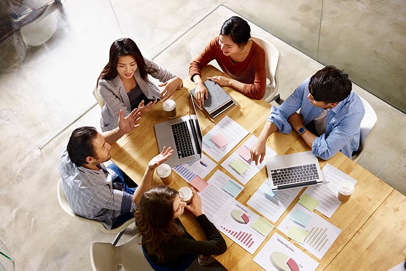 five business executives having a meeting over coffee