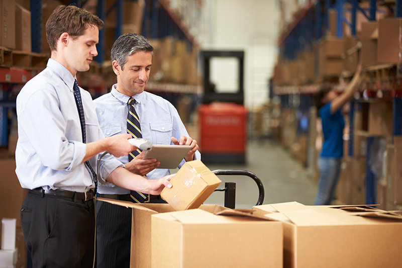 two equipment vendors packing boxes in a warehouse