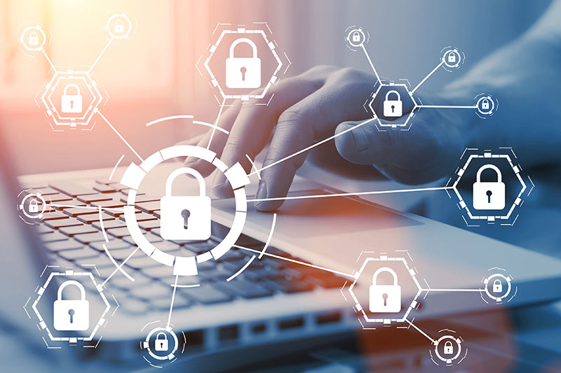 hands on a laptop computer with cybersecurity icons