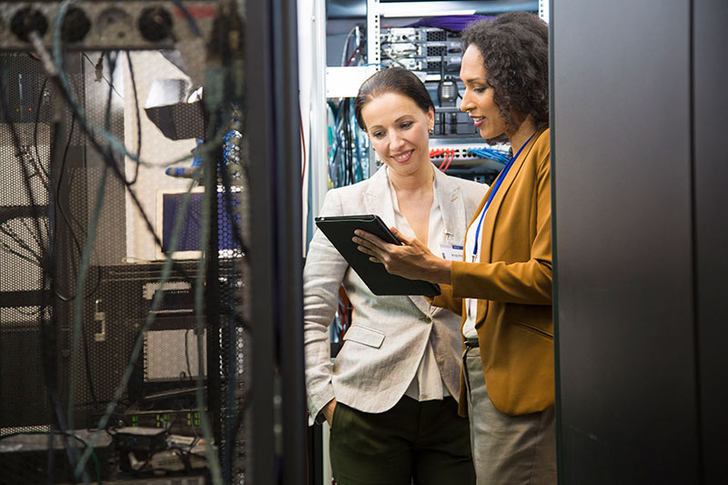 two female employees working in a computer server room