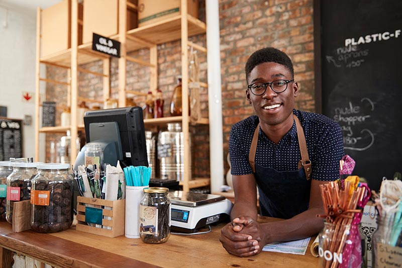 young male cafe worker smiling