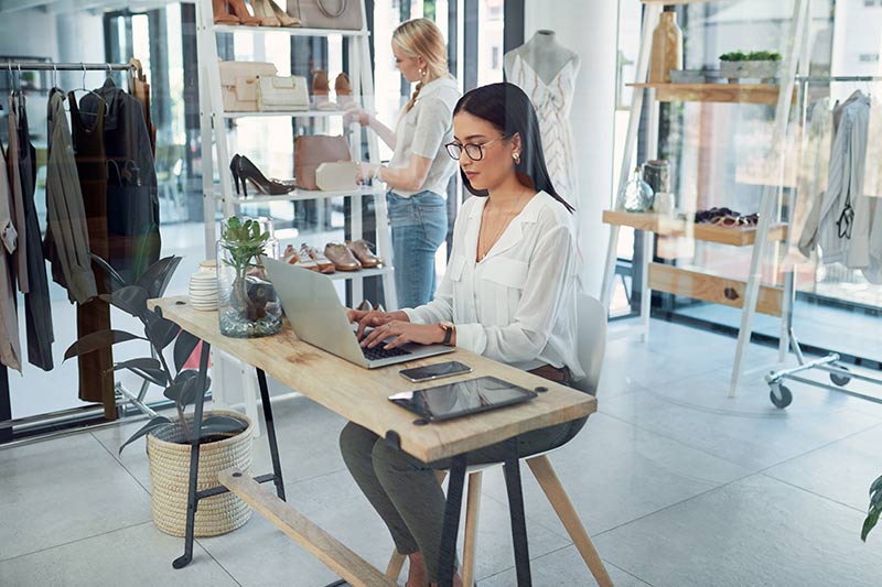 female clothing store owner using a laptop computer