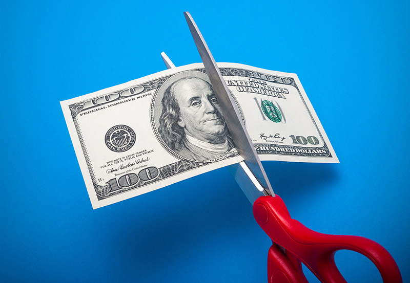 scissors cutting money