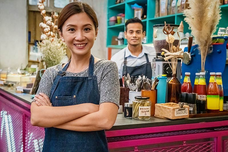 male and female retail shop owners smiling