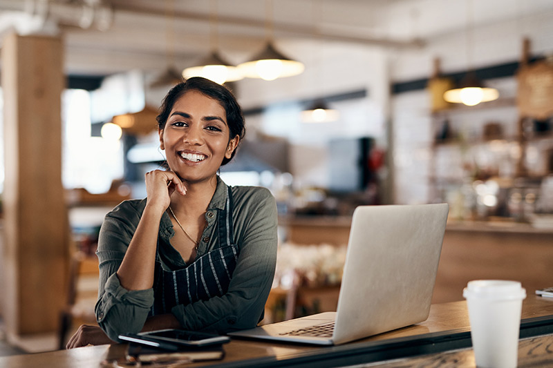 female business owner smiling in her coffee shop